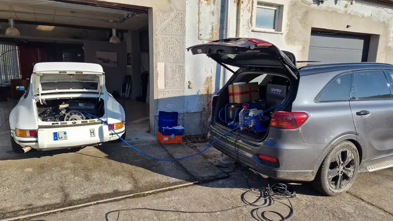 Porsche 911 und Kia Sorento bei der Wasserstoff-Motorreinigung vor der Werkstatt